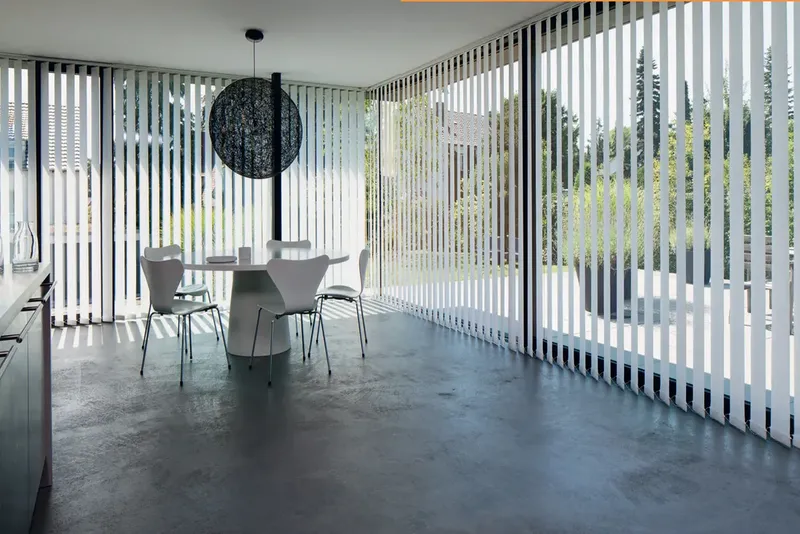 Cortina vertical traslúcida decorativa en salón con vistas al exterior